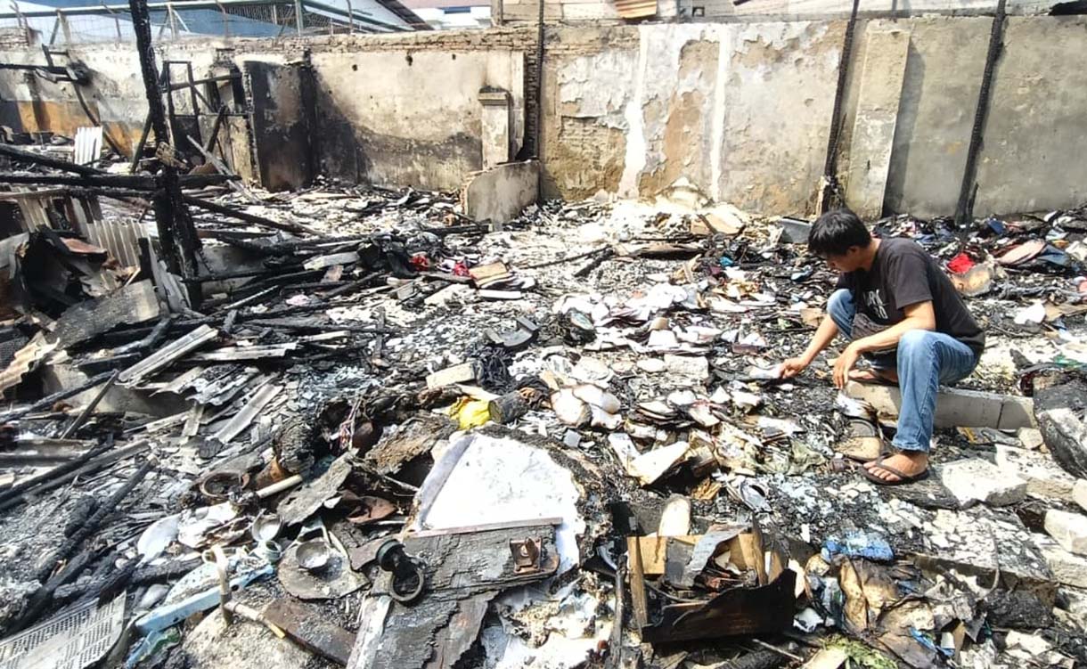 Pedagang mencari barang yang tersisa di kios yang terbakar di kawasan Kalibata, Jakarta, Jumat (12/12/2025).  (Beritanasional.com/Oke Atmaja)