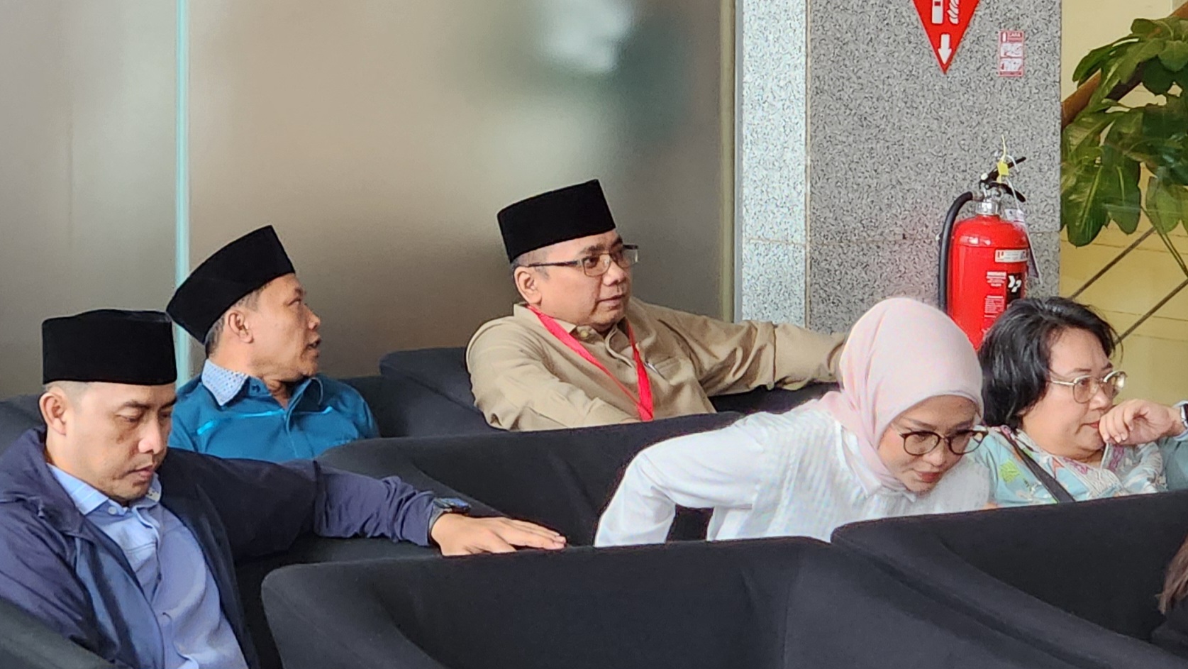 Gus Yaqut dengan tampilan tanpa kumis duduk menanti panggilan pemeriksaan KPK. (BeritaNasional/Panji)