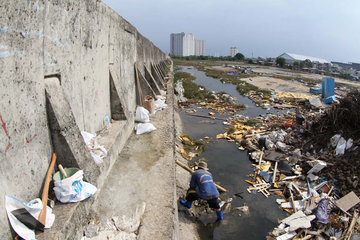 Petugas Suku Dinas Sumber Daya Air (SDA) Jakarta Utara menambal tanggul laut Muara Baru yang bocor di kawasan Muara Baru, Jakarta, Selasa(5/12/2025).  (Beritanasional.com/Oke Atmaja)