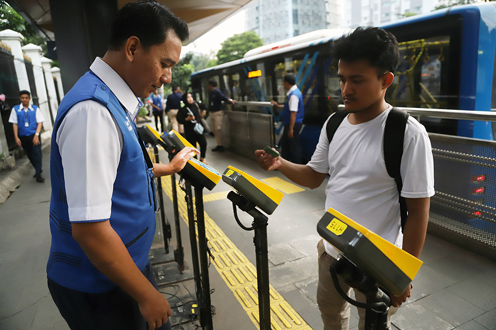 Petugas Transjakarta melayani penumpang di halte bus Jakarta. (BeritaNasional/Elvis)