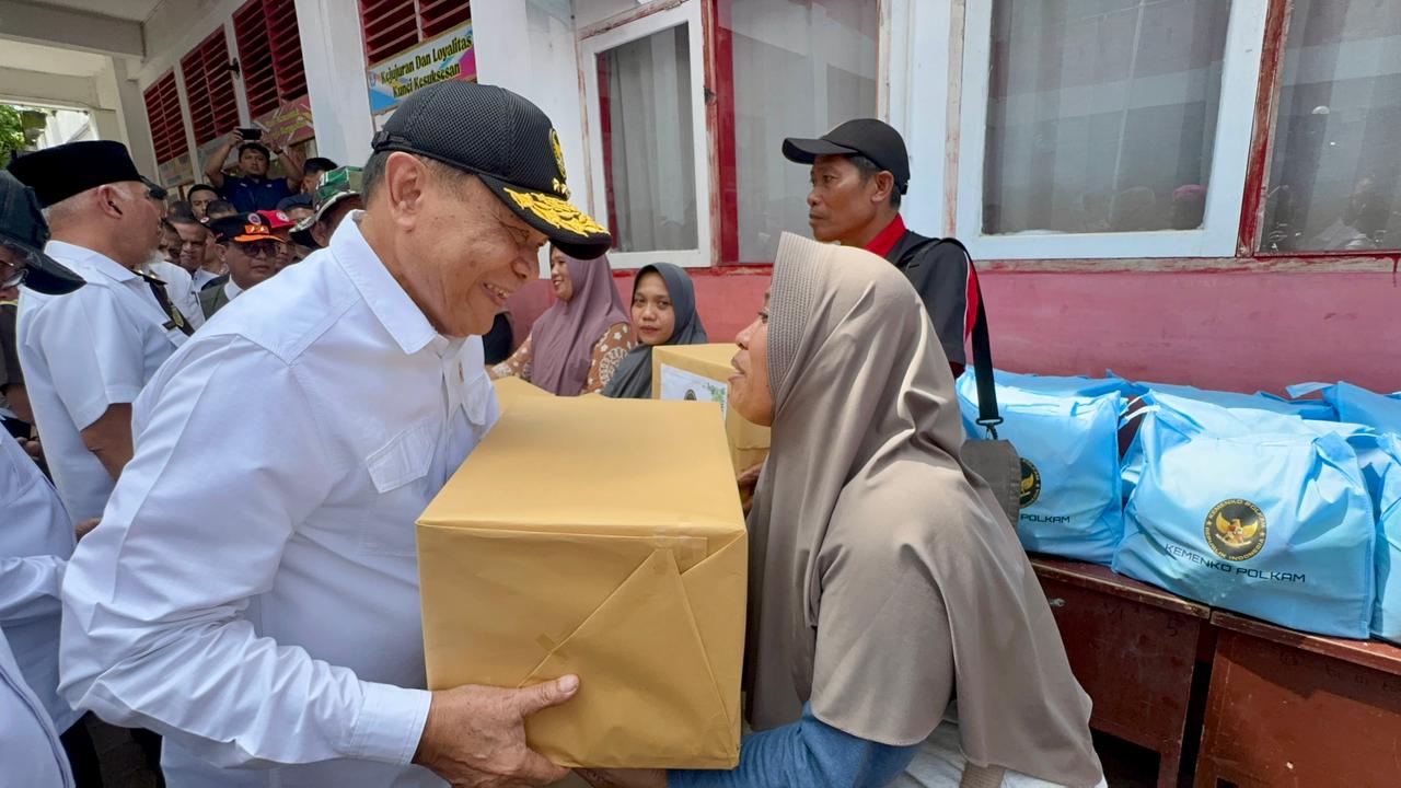 Menteri Koordinator Bidang Politik dan Keamanan Jenderal TNI (Purn) Djamari Chaniago memberikan bantuan kepada korban bencana Sumatera. (BeritaNasional/Bachtiarudin)