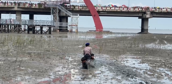 Aksi Heroik Polisi Selamatkan 2 Anak yang Terjebak Lumpur di Pantai Kenjeran. (Foto/istimewa)