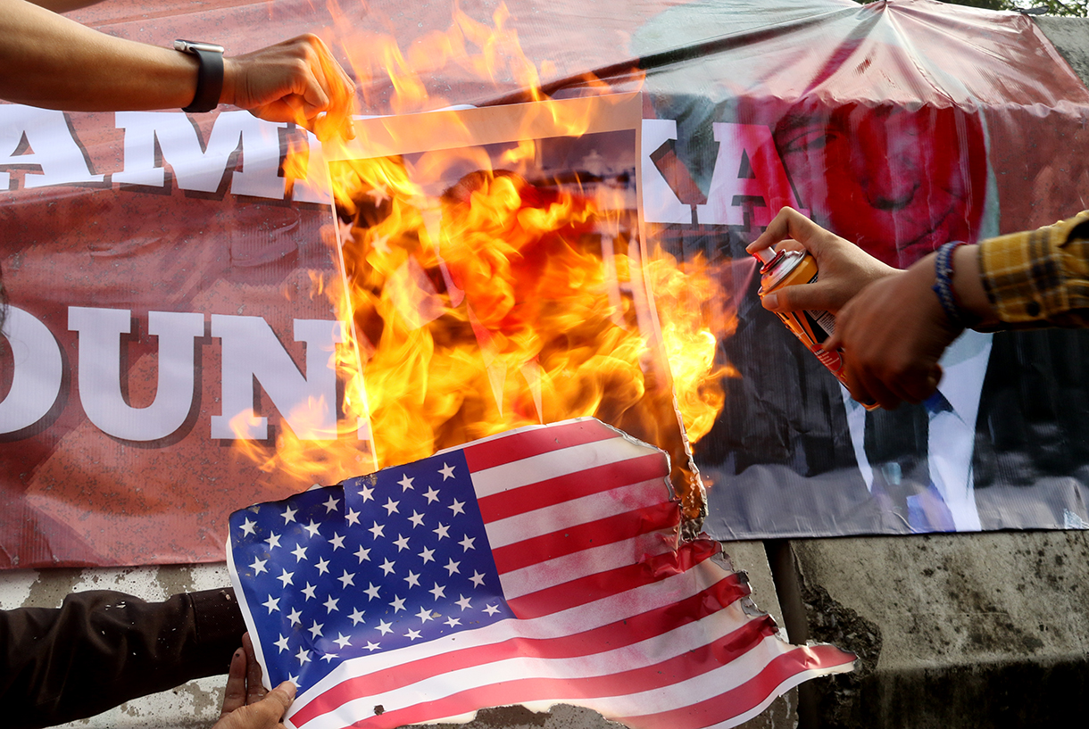 Pengunjuk rasa dari berbagai aliansi membakar bendera dan poster bergambar presiden AS Donald Trump saat menggelar aksi solidaritas untuk Venezuela di depan Kedutaan Besar Amerika Serikat, Jakarta, Selasa (6/1/2026).(Beritanasional.com/Oke Atmaja)