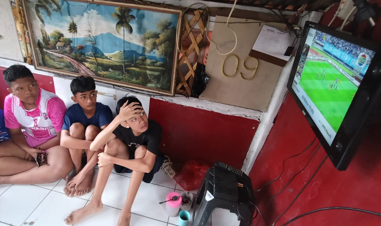 Sejumlah warga nonton bareng siaran langsung pertandingan sepak bola Super League antara Persib melawan Persija  di Menteng Jaya, Jakarta, Selasa (25/5/2025). (Beritanasional.com/Oke Atmaja)
