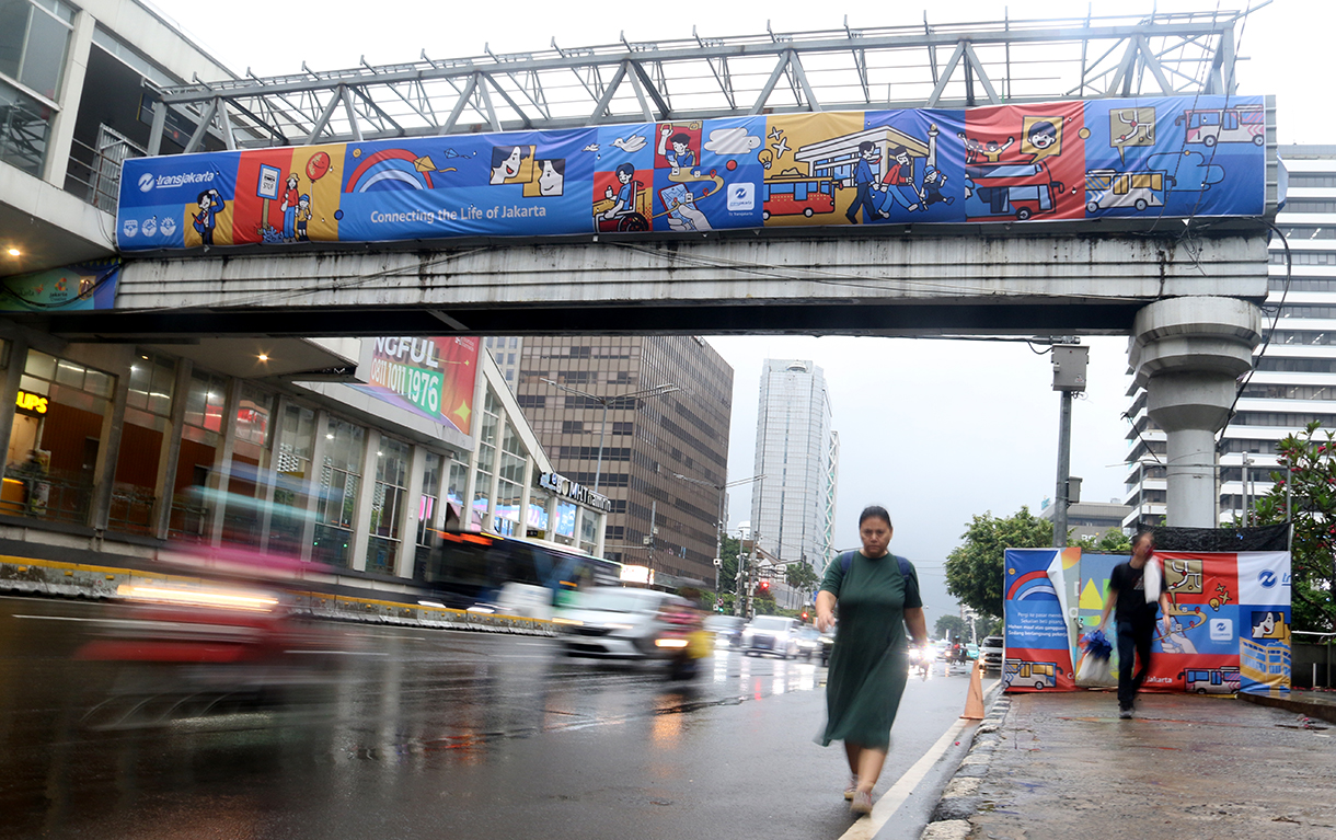 Warga melintas di Kawasan Jalan MJ Thamrin, Jakarta, Senin (12/1/2026). (Beritanasional.com/Oke Atmaja)