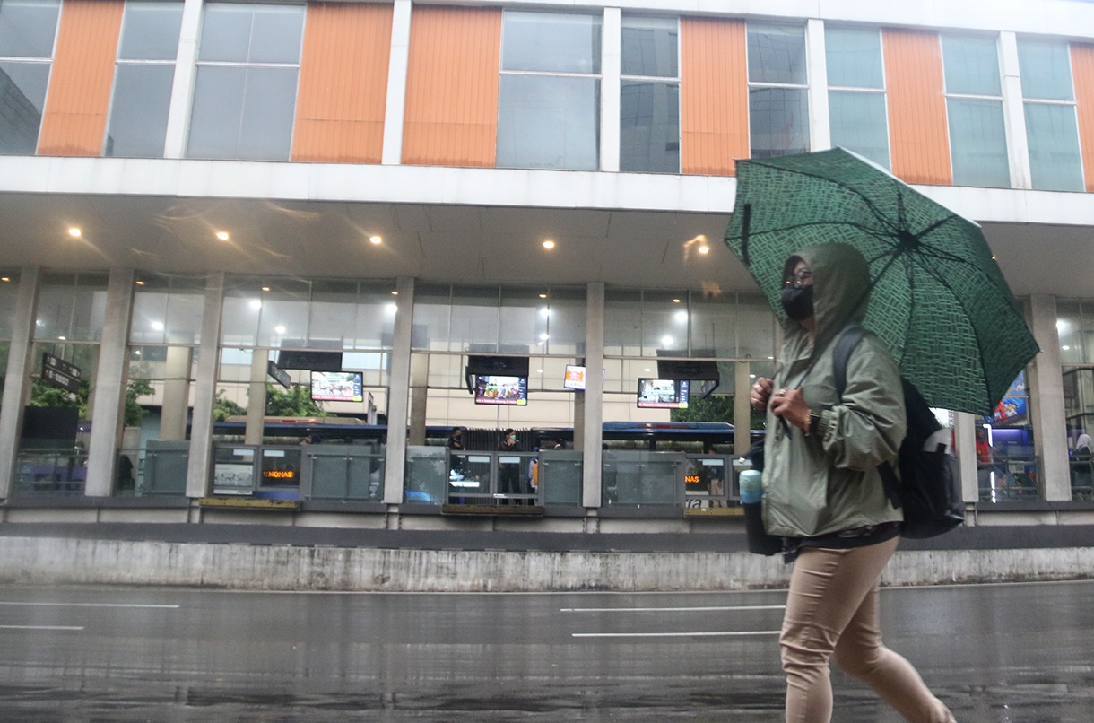 Pekerja melintas di jalan MH. Thamrin,Jakarta, Senin (12/1/2025). (Beritanasional.com/Oke Atmaja)