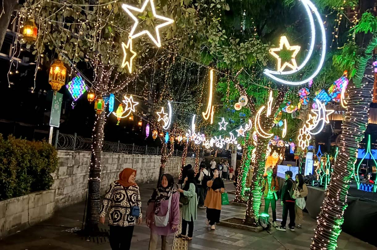 Sejumlah warga menikmati suasana di sekitar aneka lampu hias pada Jakarta Light Festival 2026 di kawasan Bundaran HI, Jakarta, Jumat (13/3/2026). (Beritanasional.com/Oke Atmaja)