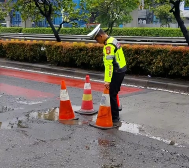 Polisi memberikan tanda peringatan pada jalan berlubang. (Foto/Istimewa)