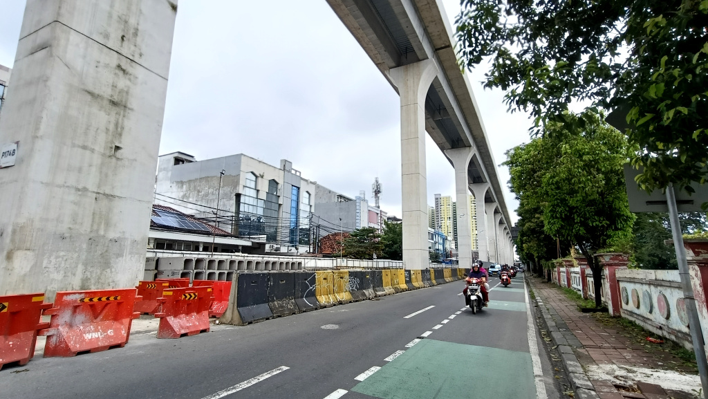 kendaraan melintas disamping pembangunan jalur Light Rail Transit (LRT) Jakarta Fase 1B berlangsung di Manggarai, Jakarta, Kamis (26/3/2026).  (Beritanasional.com/Oke Atmaja)