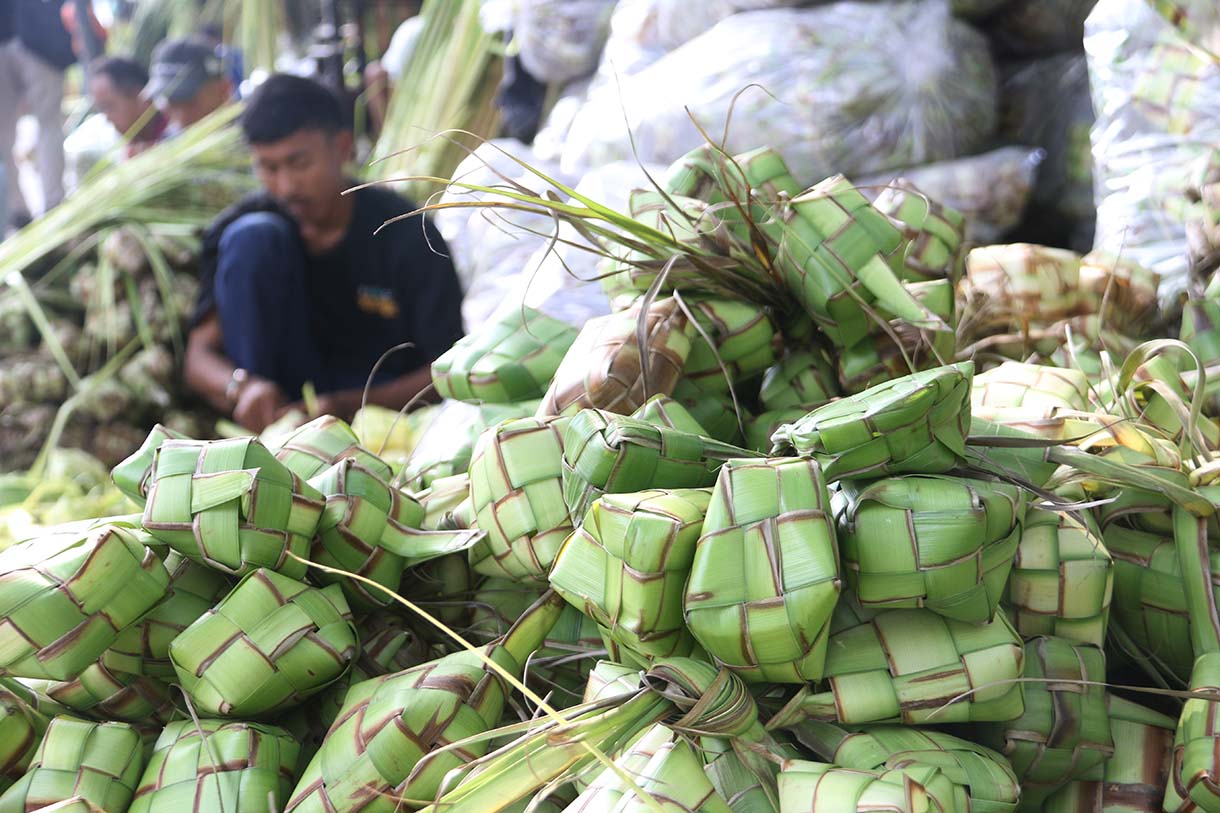 Pedagang menganyam kulit ketupat di Pasar Pondok Labu, Jakarta, Jumat (20/3/2026).(Beritanasional.com/Oke Atmaja)