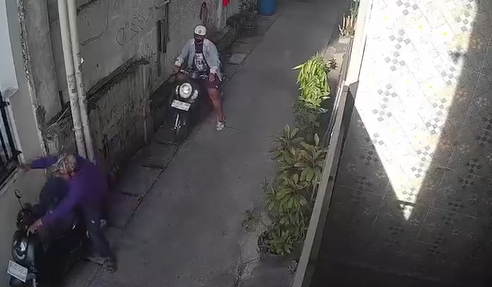 Pelaku pencuri motor di Tanjung Priok berpakaian biru sedang menendang setang motor. (BeritaNasional/tangkapan layar)