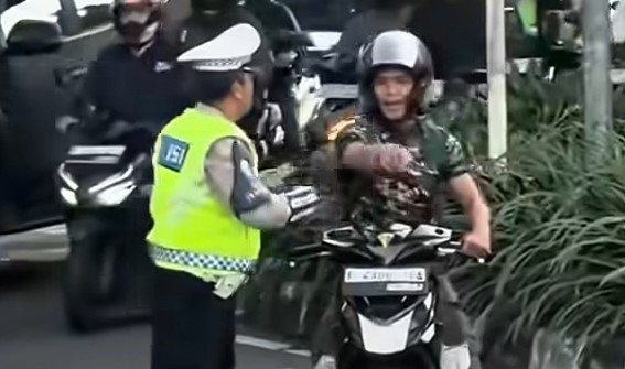 Polantas menegur pria yang diduga anggota TNI yang hendak melawan arah di kawasan UKI, Jaktim. (Foto/Istimewa)