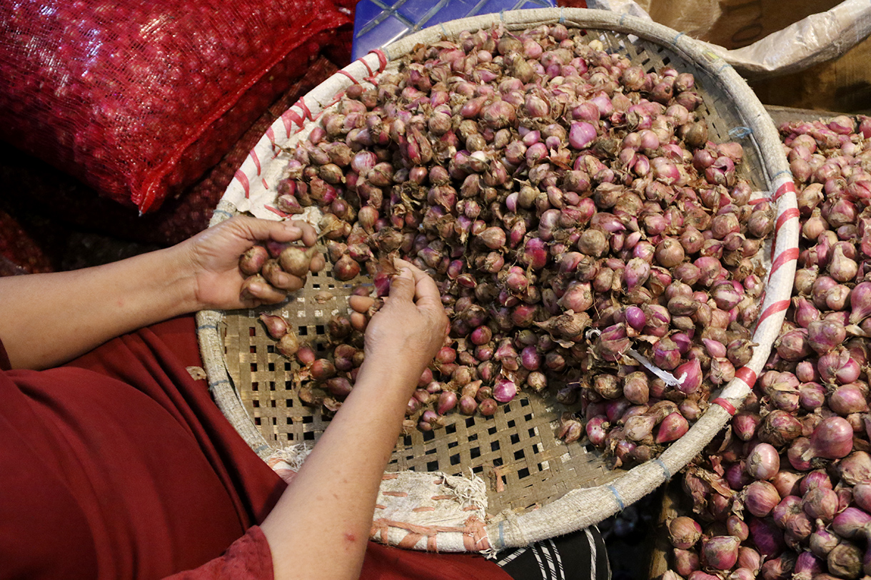 Pedagang sedang menilah bawang putih di Pasar Induk, Kramat Jati, Jakarta, Sabtu (11/4/2026).(Beritanasional.com/Oke Atmaja)