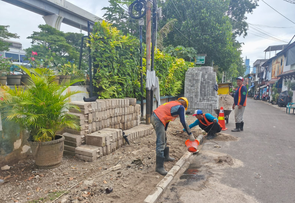 Pekerja menyelesaikan proyek revitalisasi trotoar di Menteng Tenggulun, Jakarta, Jumat (10/4/2026). (Beritanasional.com/Oke Atmaja)