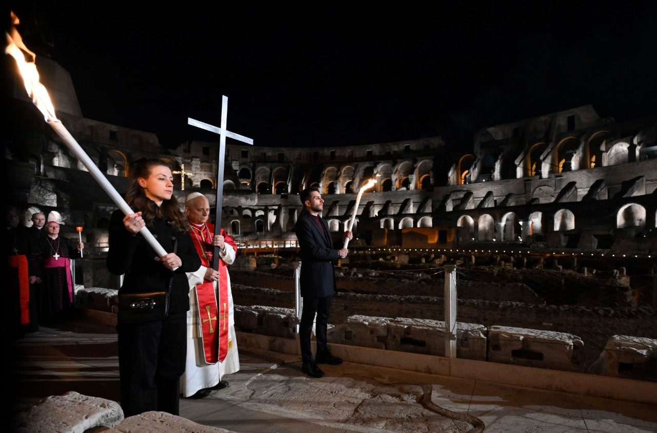 Paus Leo XIV memengan salib dalam prosesi Via Crucis di Colosseum, Roma. (Foto/Vatican News)
