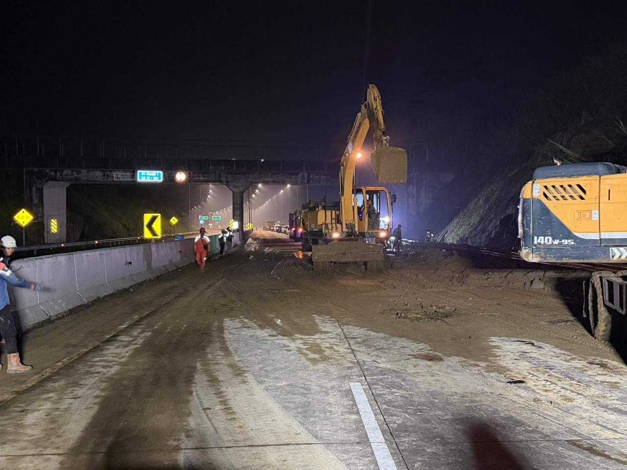 Pekerja membersihkan material tanah longsor di tol Bocimi. (BeritaNasional/KemenPU)