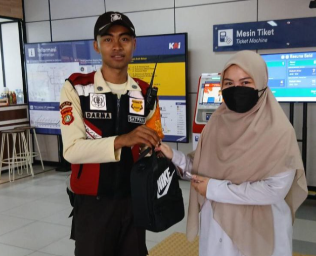 Satuan pengamanan LRT menyerahkan barang yang tertinggal di LRT kepada salah satu penumpang. (BeritaNasional/dok LRT)