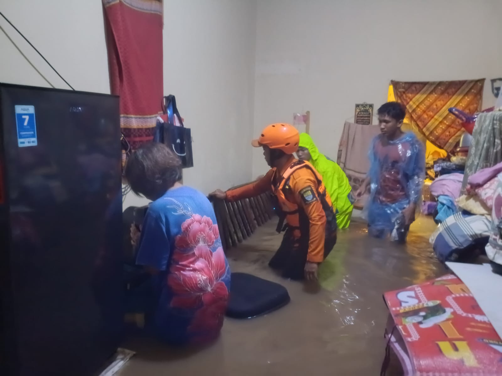 Tim penyelamat membantu salah satu warga korban banjir di Cirebon Jawa Barat. (BeritaNasional/BNPB)