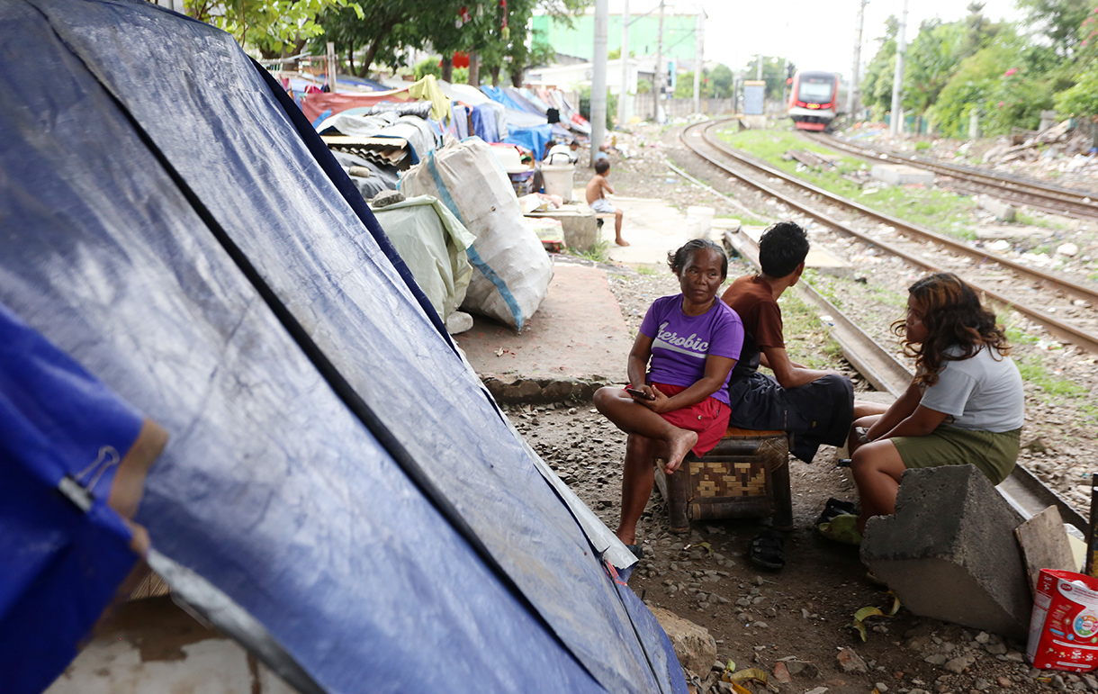 Warga bercengkrama di depan rumah nonpermanen di bantaran rel kawasan Senen, Jakarta, Rabu(6/5/2026).  (Beritanasional.com/Oke Atmaja)