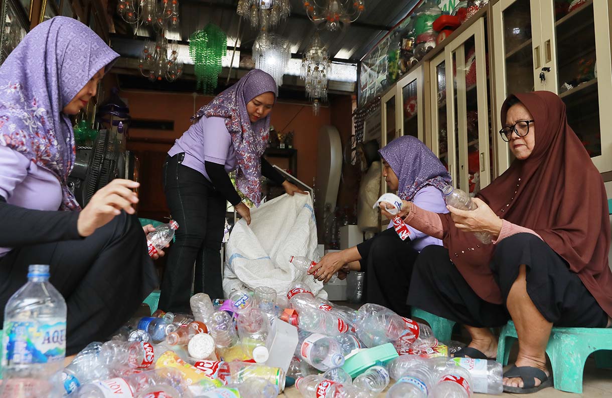 Warga melakukan proses sortir sampah botol plastik untuk didaur ulang di Bank Sampah Persatuan, Jalan Persatuan RW 08, Pondok Kelapa, Duren Sawit, Jakarta, Selasa (9/6/2026). (Beritanasional.com/Oke Atmaja)