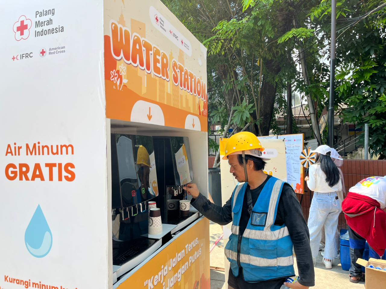 Seorang pekerja luar ruang memanfaatkan fasilitas air gratis yang disediakan PMI. (BeritaNasional/PMI)