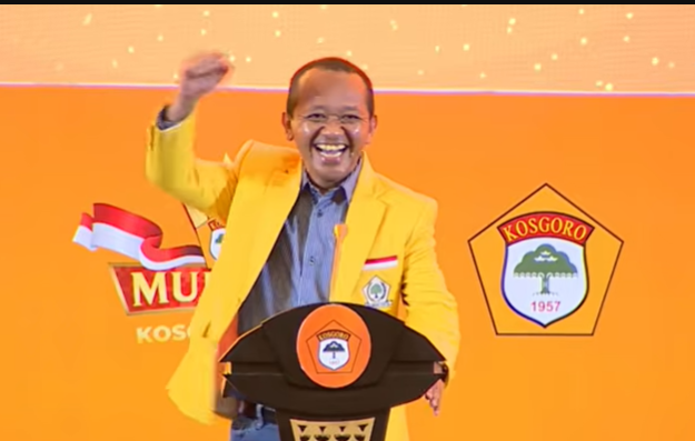 Ketum Golkar Bahlil Lahadalia saat mendengar lagu MBG alias Mas Bahlil Ganteng di Mubes V Kosgoro, Jumat (5/6/2026) malam. (Beritanasional/YT Kabar Golkar)
