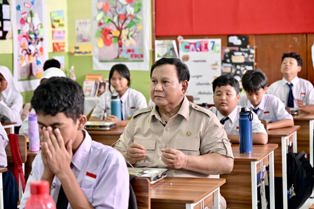 Presiden Prabowo Subianto duduk bersama murid SMPN 111 Jakarta saat meninjau pemberian MBG. (BeritaNasional/Setpres)