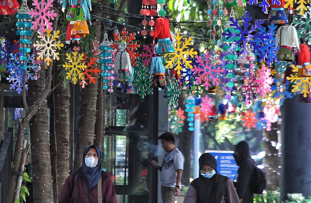 Warga melintas jalan di kawasan Jakarta Pusat yang dipenuhi hiasan tematk budaya Betawi sambut HUT Jakarta 499. (BeritaNasional/Elvis Sendouw)