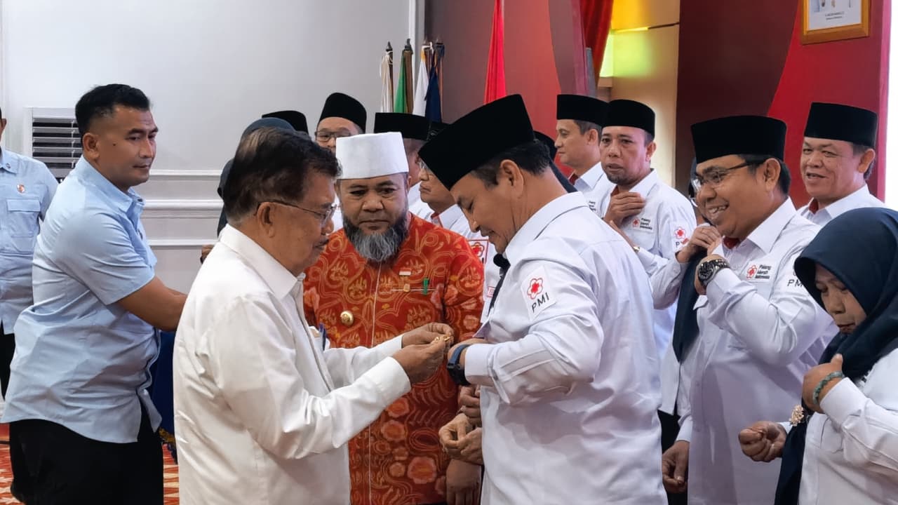 Ketua Umum Palang Merah Indonesia (PMI) Jusuf Kalla menyematkan pin usai melantik Ketua PMI Bengkulu Herwan Anthoni. (BeritaNasional/istimewa)