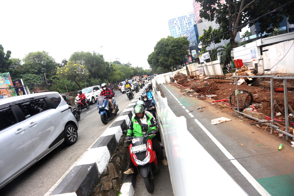 Sejumlah kendaraan sepeda motor melintasi dekat kawasan proyek pembangunan Jembatan Penyebrangan Orang (JPO) di Jalan Warung Jati Barat, Pejaten, Jakarta Selatan, Rabu (8/7/2026). (Beritanasional.com/Oke Atmaja)