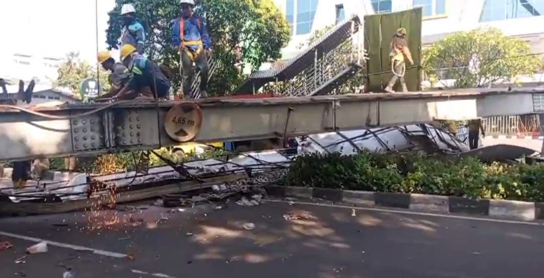 Petugas mengamankan lokasi Jembatan Penyeberangan Orang (JPO) di Jalan Kapten Tendean, Jakarta Selatan, Selasa (14/7/2026). (Beritanasional.com/Oke Atmaja)