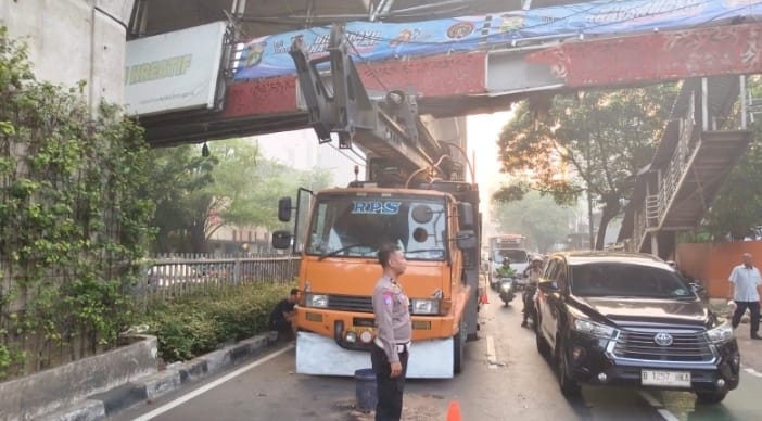 Polisi lalu lintas berjaga mengatur arus lalu lintas kendaraan di lokasi truk nyangkut di Mampang Prapatan Jaksel. (BeritaNasional/X Polda Metro Jaya)