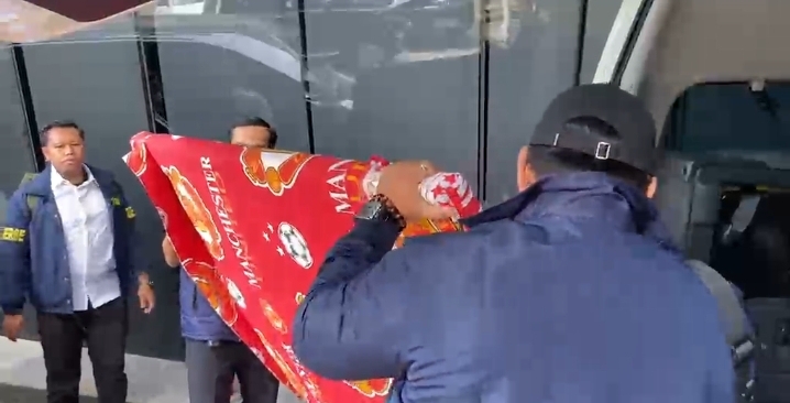 Penyidik polri membawa bingkai besar yang ditutupi kain MU. (BeritaNasional/Bahctiarudin)