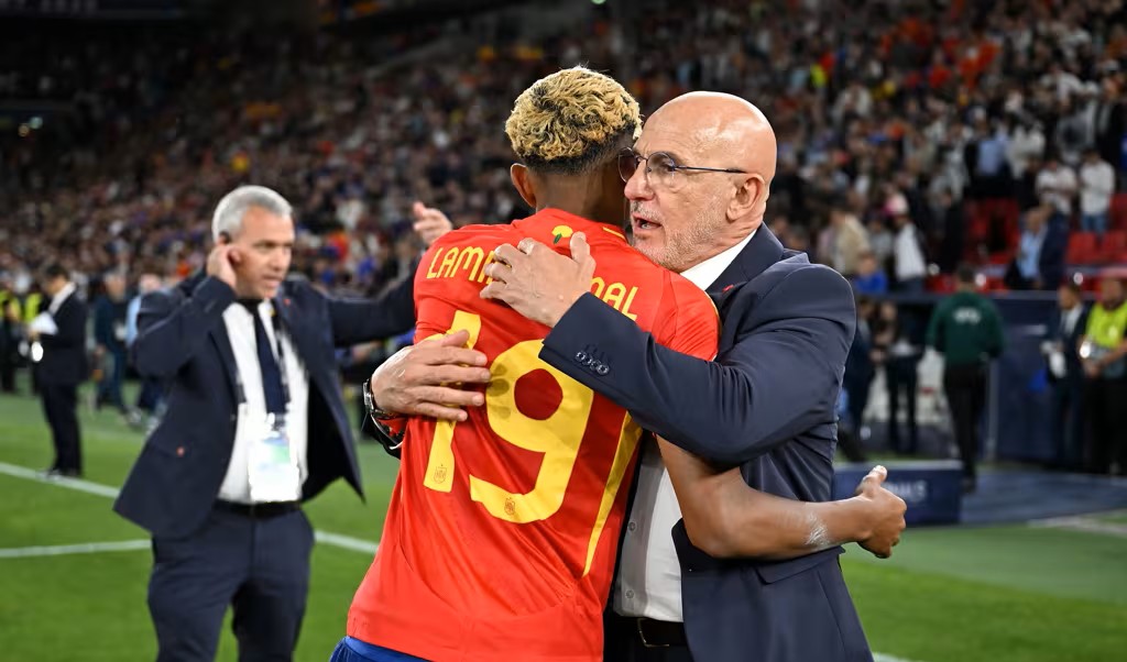 Pelatih Timnas Spanyol Luis de la Fuente (kanan) memeluk anak asuhnya, Lamine Yamal. (Foto/FIFA)