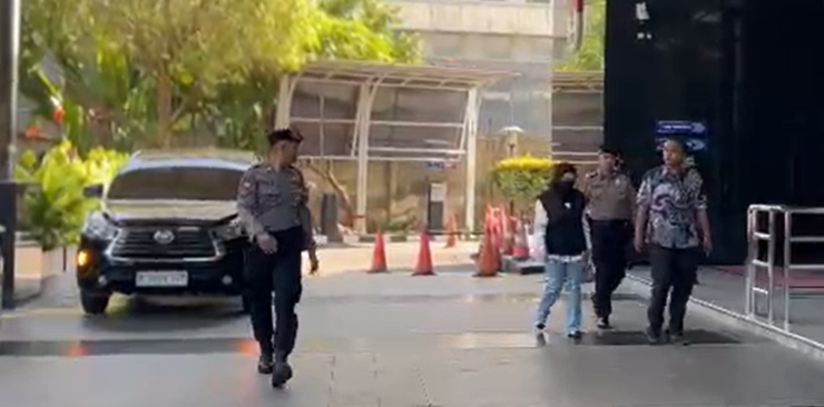Bupati Sukoharjo Etik Suryani kenakan masker hitam dan jelana jins turun dari mobil hitam di selasar gedung KPK Jakarta. (BeritaNasional/Panji)