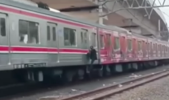 Pria nekat bergelantungan di luar KRL. (Foto/Ist)