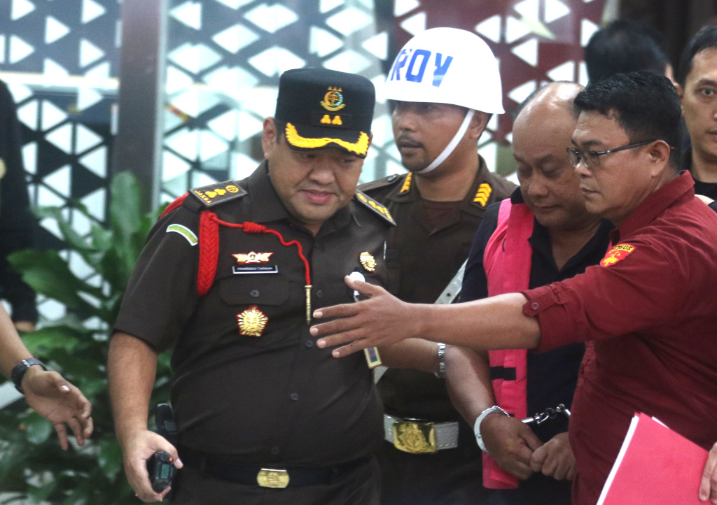 Tersangka dugaan tindak pidana korupsi tata kelola program Makan Bergizi Gratis (MBG) pada Badan Gizi Nasional (BGN) Lodewyk Pusung (tengah) berjalan memasuki mobil tahanan di Kejaksaan Agung, Jakarta, Rabu (3/6/2026).  (Beritanasional.com/Oke Atmaja)