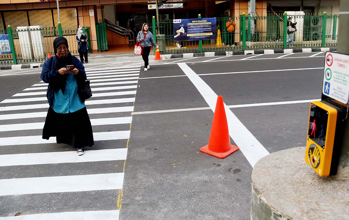 Warga menyeberang jalan menggunakan pelican crossing di sisi timur Stasiun Cikini, Jakarta, Selasa(16/9/2025).  (Beritanasional.com/Oke Atmaja)