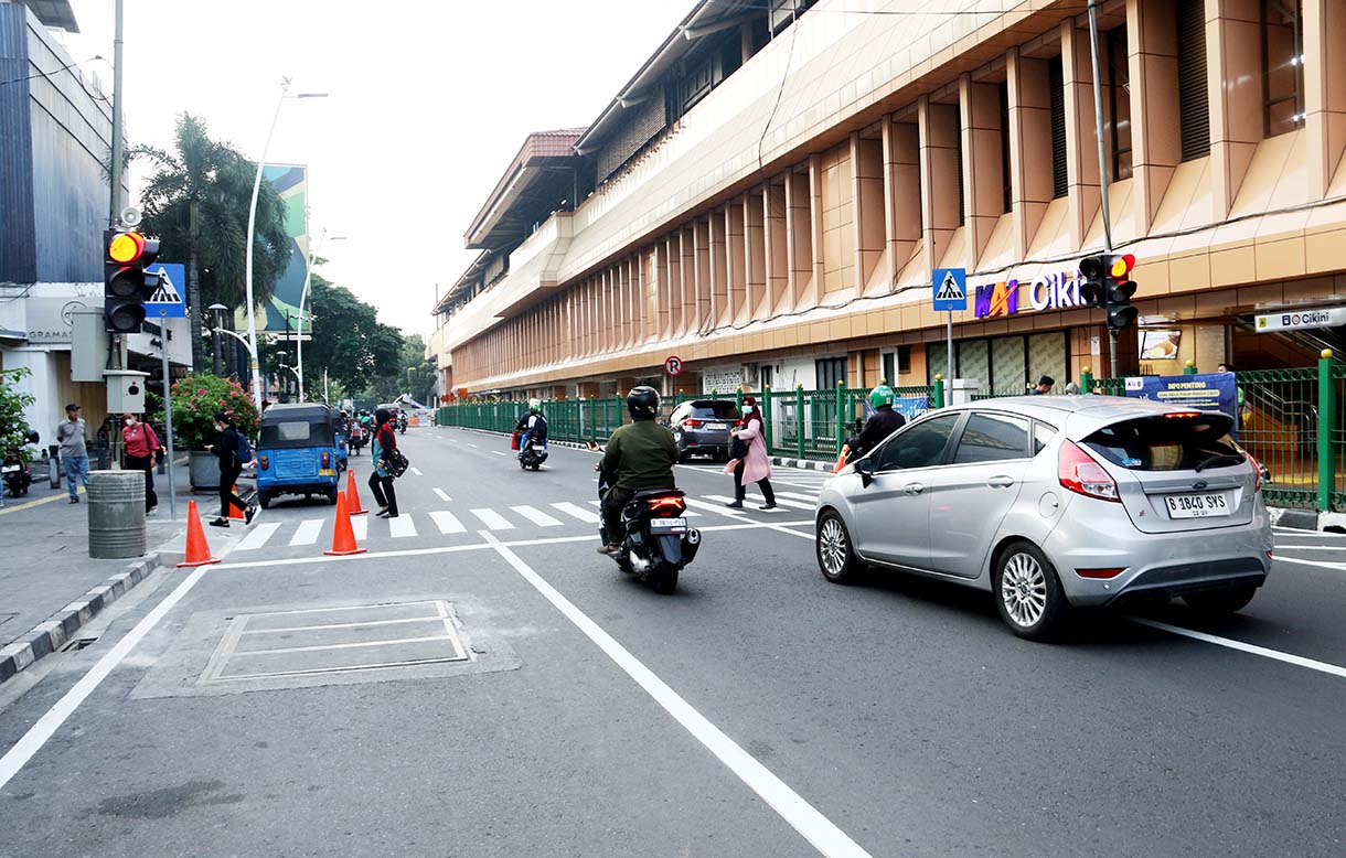Warga menyeberang jalan menggunakan pelican crossing di sisi timur Stasiun Cikini, Jakarta, Selasa(16/9/2025).  (Beritanasional.com/Oke Atmaja)