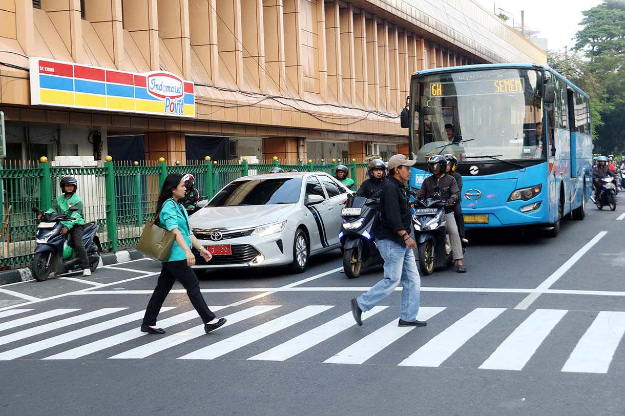 Warga menyeberang jalan menggunakan pelican crossing di sisi timur Stasiun Cikini, Jakarta, Selasa(16/9/2025).  (Beritanasional.com/Oke Atmaja)
