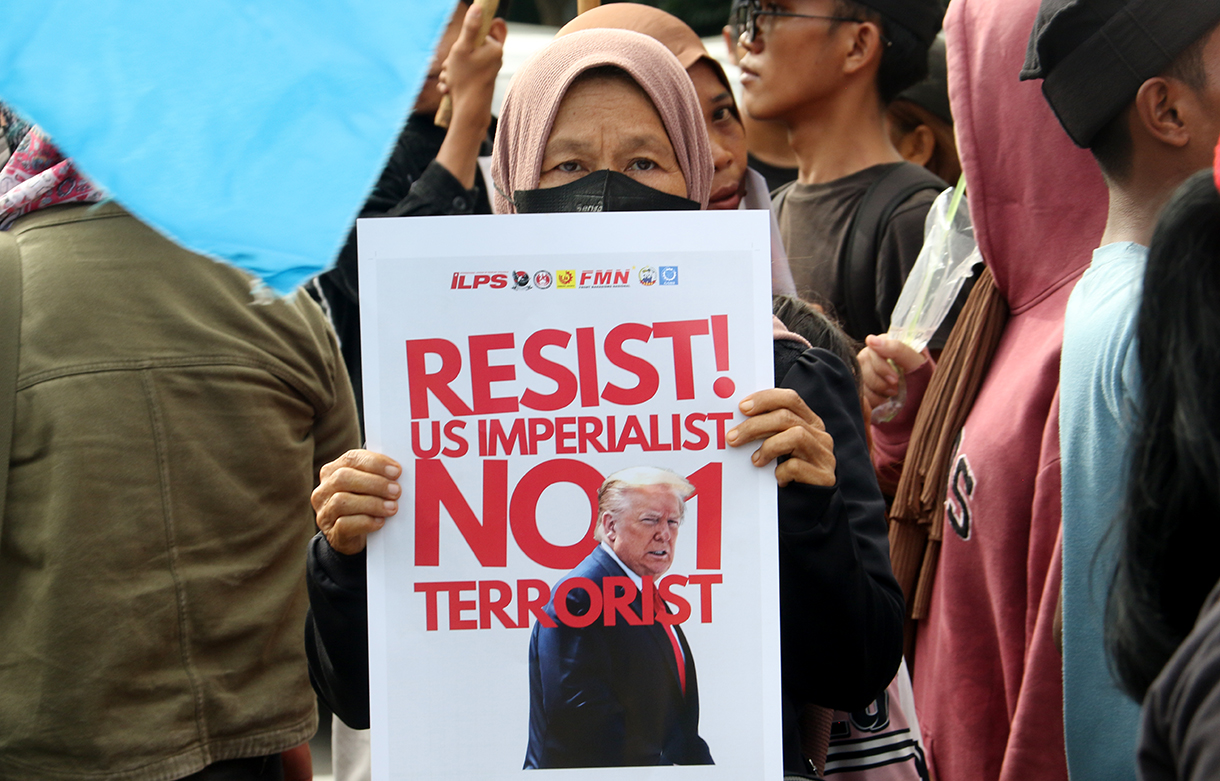 Pengunjuk rasa dari berbagai aliansi membakar bendera dan poster bergambar presiden AS Donald Trump saat menggelar aksi solidaritas untuk Venezuela di depan Kedutaan Besar Amerika Serikat, Jakarta, Selasa (6/1/2026).(Beritanasional.com/Oke Atmaja)