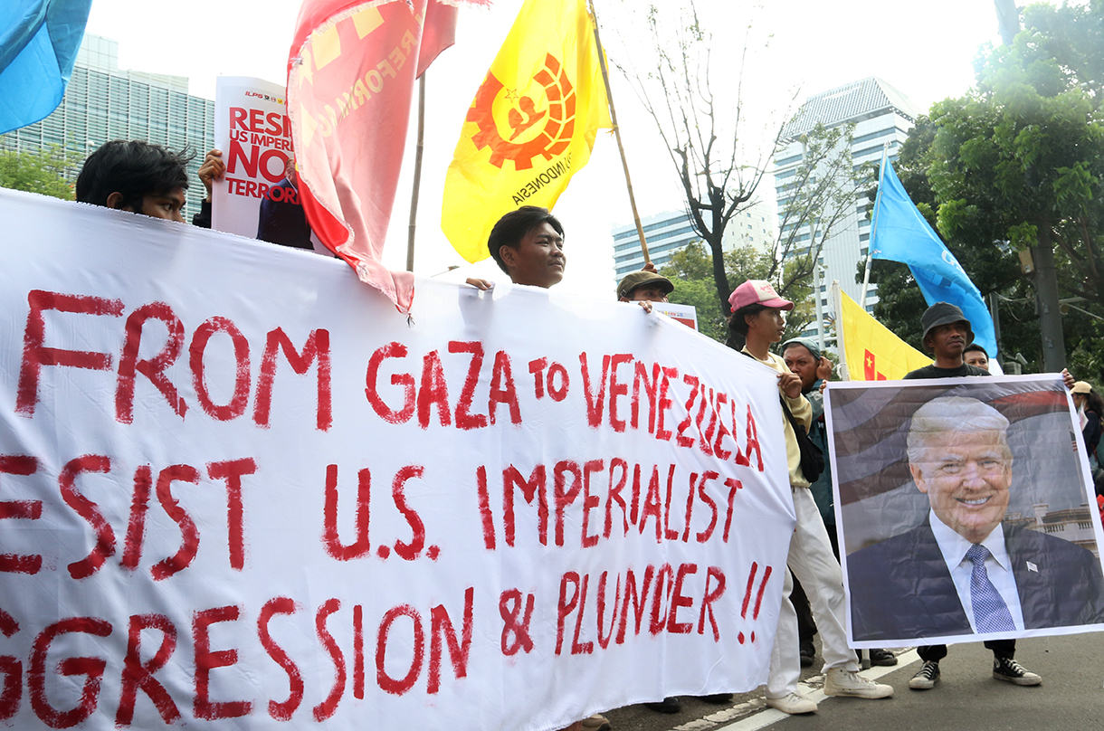 Pengunjuk rasa dari berbagai aliansi membakar bendera dan poster bergambar presiden AS Donald Trump saat menggelar aksi solidaritas untuk Venezuela di depan Kedutaan Besar Amerika Serikat, Jakarta, Selasa (6/1/2026).(Beritanasional.com/Oke Atmaja)