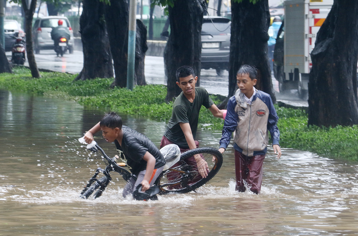 Seorang anak bermain di genangan air di wilayah Jakarta. (Beritanasional.com/Oke Atmaja)