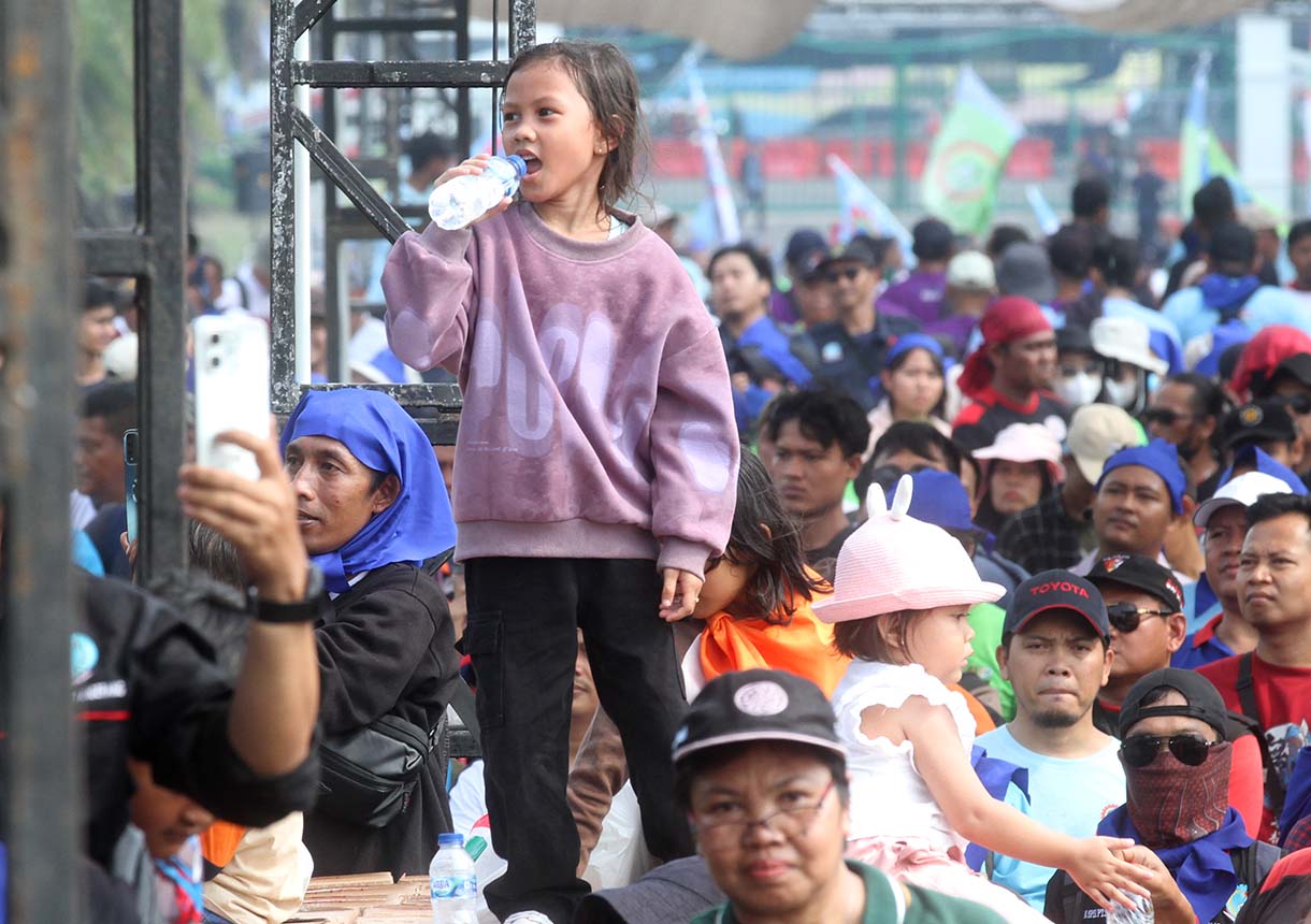 Buruh membawa anaknya saat peringati hari buruh di Lapangan Monas, Jakarta Pusat, Kamis (1/5/2025).(Beritanasional.com/Oke Atmaja)