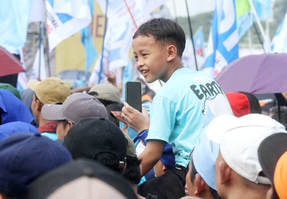 Buruh membawa anaknya saat peringati hari buruh di Lapangan Monas, Jakarta Pusat, Kamis (1/5/2025).(Beritanasional.com/Oke Atmaja)