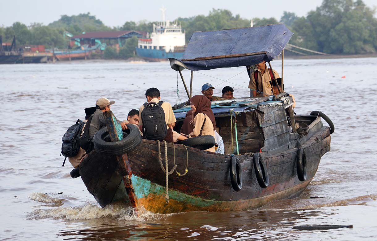 Warga Kuala Selat, Indragiri Hilir, Riau, merawat bibit mangrove di sekitar kebun kelapa yang rusak akibat abrasi laut, Kamis (25/9/2025).  (Beritanasional.com/Oke Atmaja)