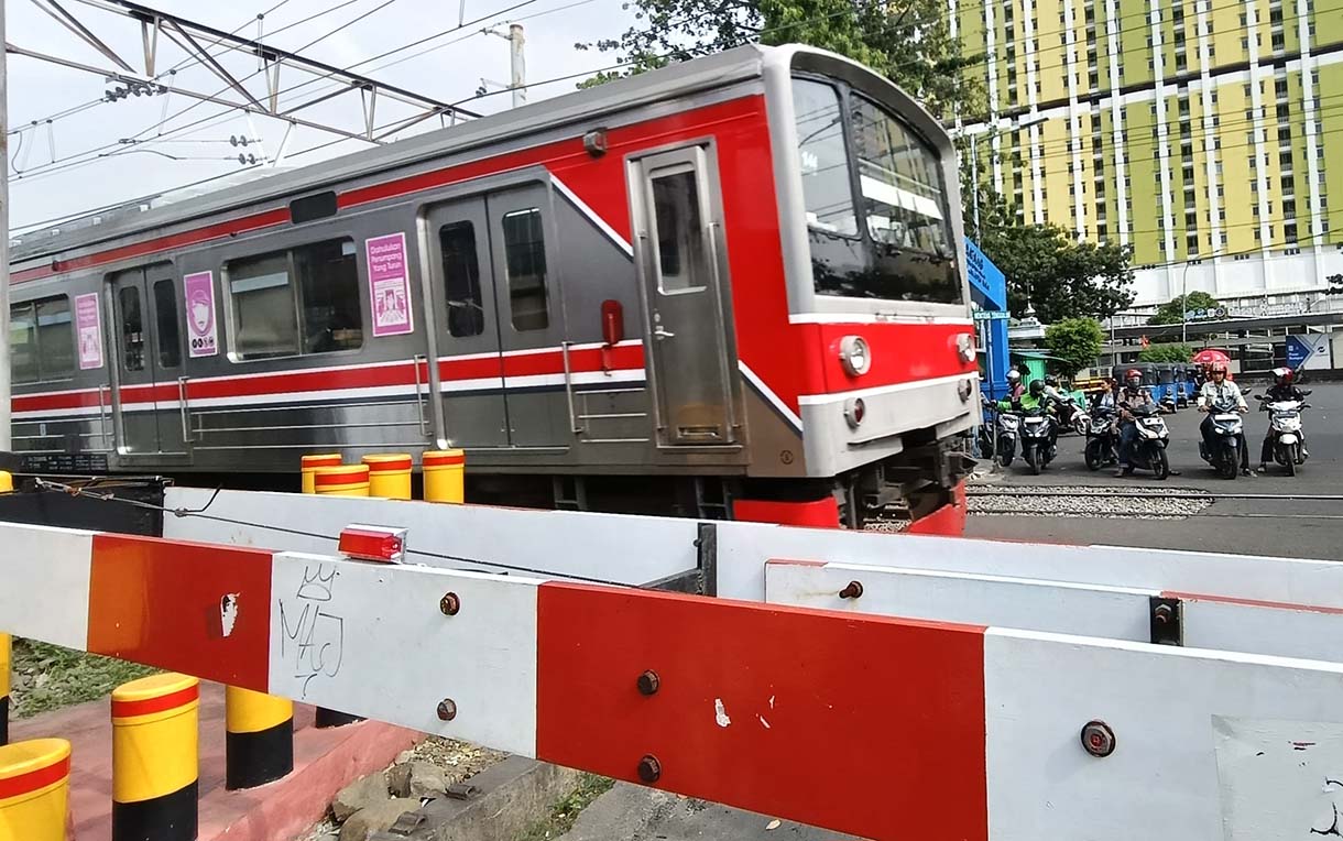 Angka Kecelakaan di Perlintasan Kereta Api Jakarta Pengendara motor menunggu kereta api melintas di Kawasan stasiun manggarai, Jakarta, Rabu(7/5/2025). (Beritanasional.com/Oke Atmaja)