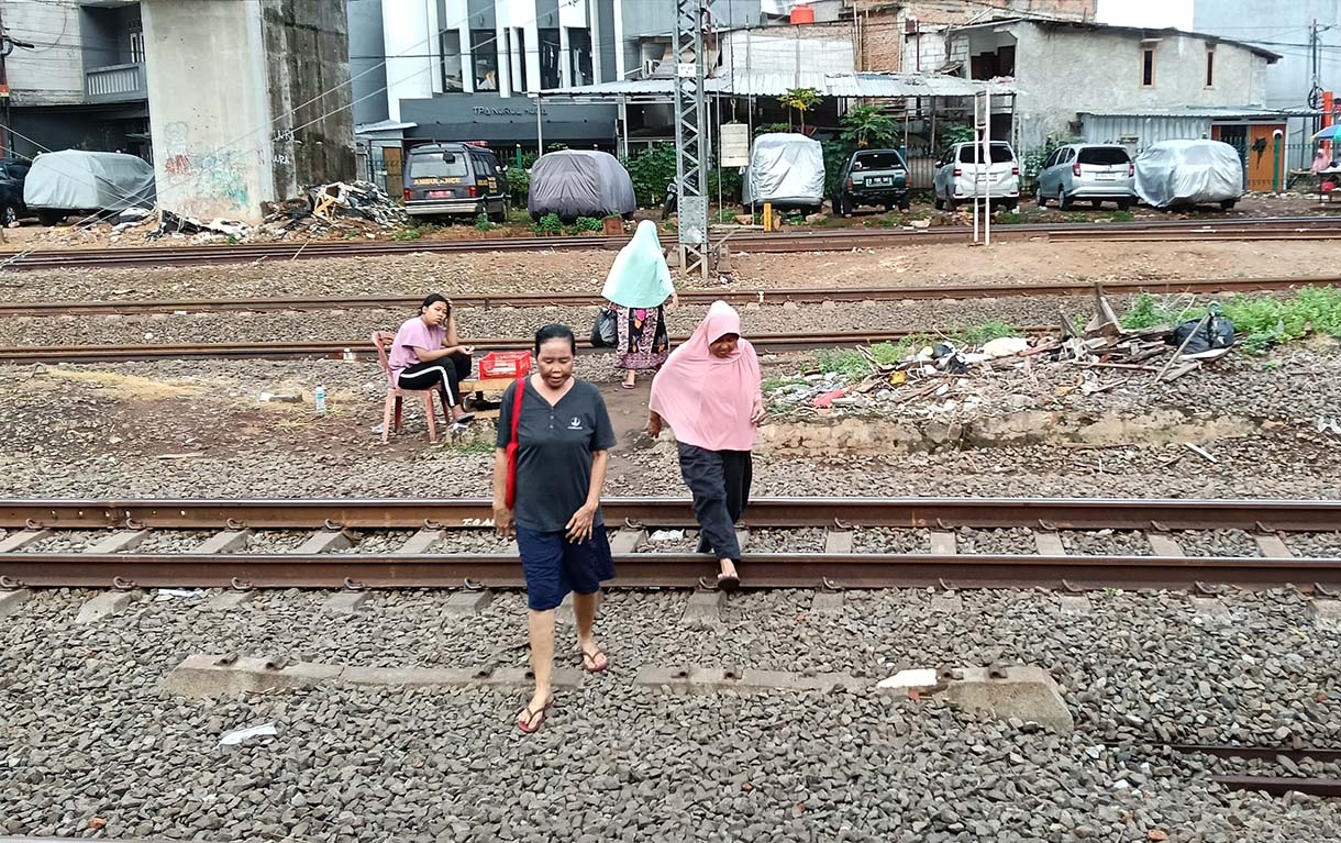 Angka Kecelakaan di Perlintasan Kereta Api Jakarta Pengendara motor menunggu kereta api melintas di Kawasan stasiun manggarai, Jakarta, Rabu(7/5/2025). (Beritanasional.com/Oke Atmaja)