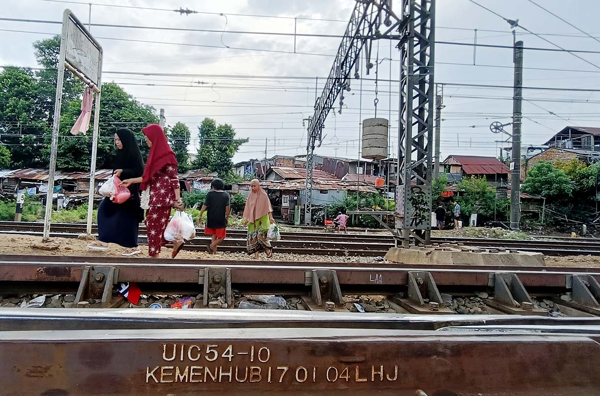 Angka Kecelakaan di Perlintasan Kereta Api Jakarta Pengendara motor menunggu kereta api melintas di Kawasan stasiun manggarai, Jakarta, Rabu(7/5/2025). (Beritanasional.com/Oke Atmaja)