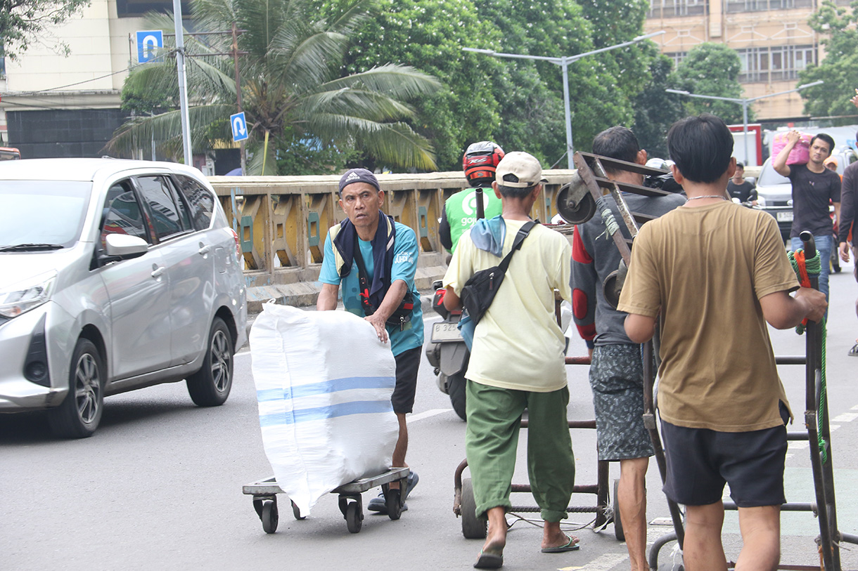 Buruh angkut membawa barang di kawasan Pasar Tanah Abang, Jakarta, Kamis (26/2/2025).(Beritanasional.com/Oke Atmaja)